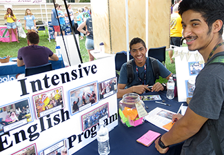student at fair booth table learning about the intensive english program