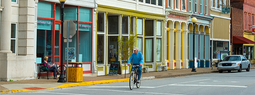 A bicyclist rides down main street in New Harmony