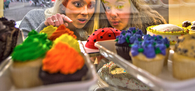 two students, looking into glass of baked treats, pointing