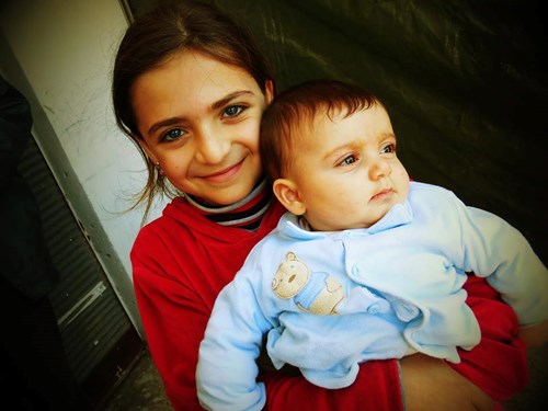 Syrian girl holding a baby