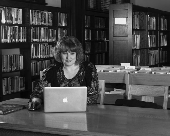 Gibson researching on her computer in a library