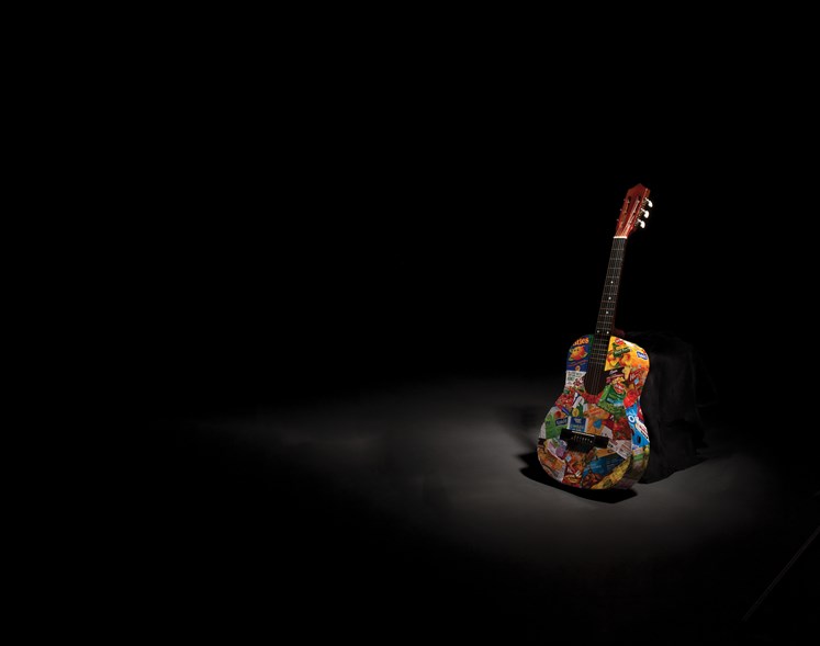 colorful guitar sitting in a dark room