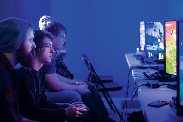 Gamers playing games on PCs in a dark room