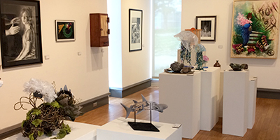 Shot of gallery showing paintings, drawings, ceramics, sculpture, woodworking, on display
