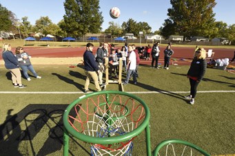 USI OT students help EVSC students use an adaptive basketball catapult during EVSC Special Olympics Unified Champions Game Day