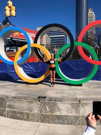 Julia Kohnen standing in front of Olympic rings