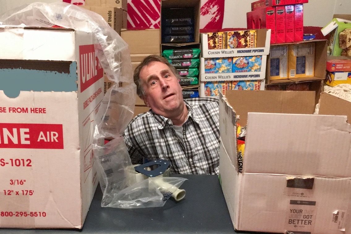 Chuck Armstrong amongst his packages and supplies