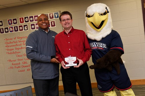 Jeff Sickman holds his 2019 Screagle Pride Award next to President Ronald Rochon and Archie