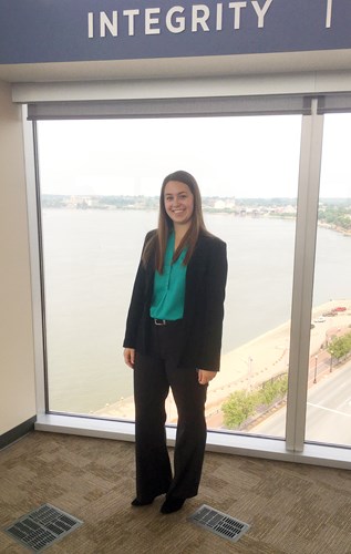 Mara in front of a window that overlooks the Ohio River in downtown Evansville