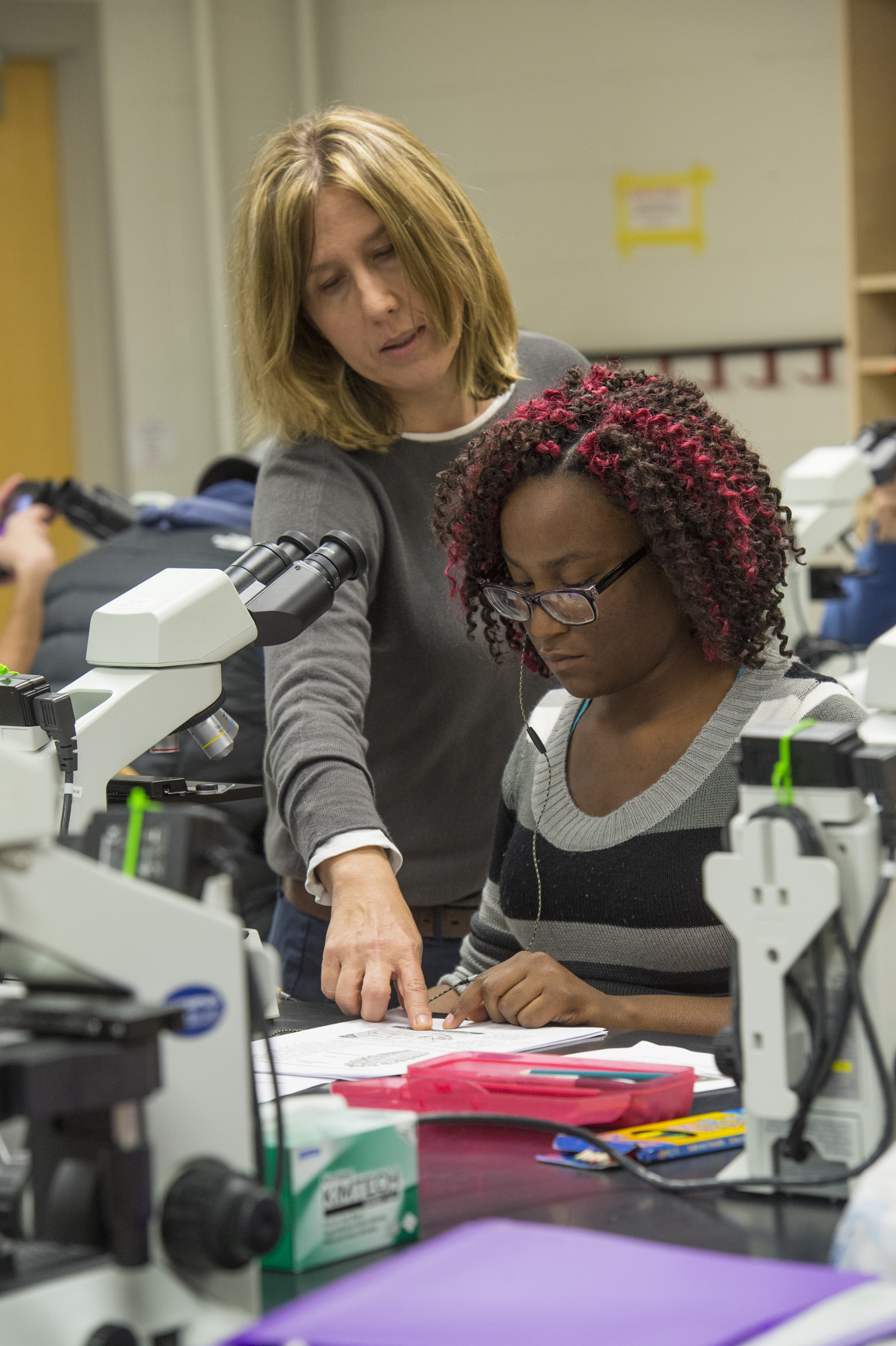 Dr. Edie Hardcastle works closely with a student at a microscope