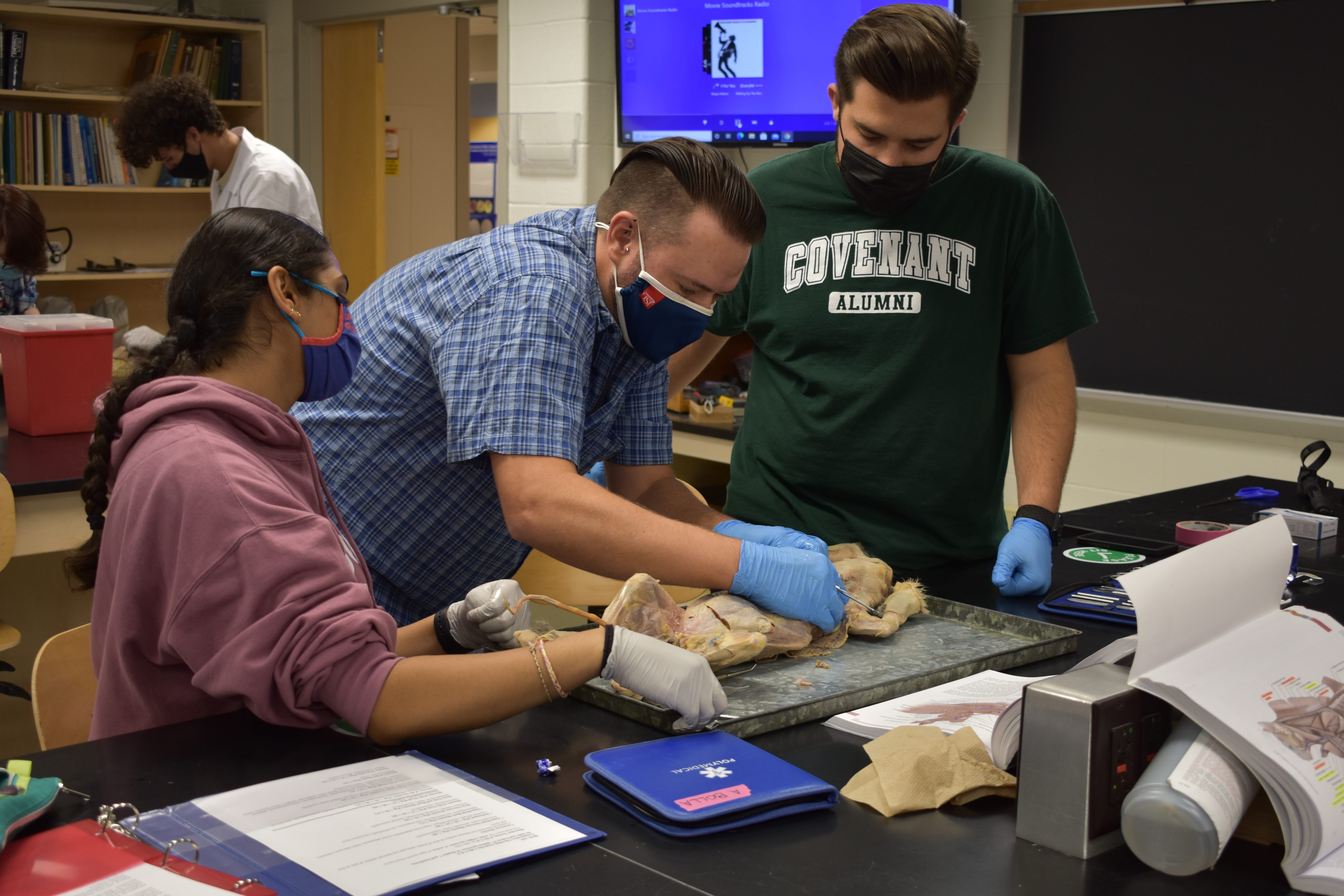 Dr. Kyle Mara works shows USI Biology students how to dissect a specimen.