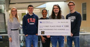 team members holding a check