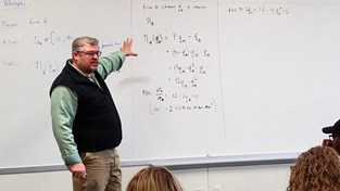 Price pointing to equation on whiteboard